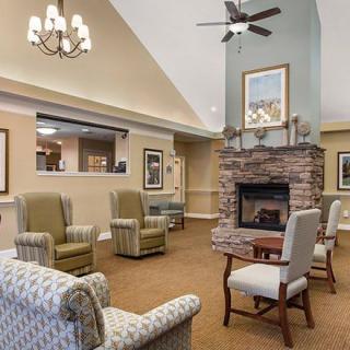A cozy living area with armchairs, a fireplace, and elegant lighting.