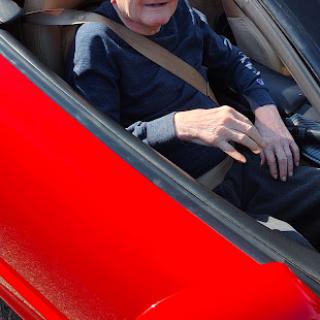 A person enjoying a drive in a red car.