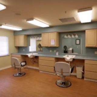 An interior view of a salon with chairs, mirrors, and cabinets.