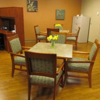 A cozy dining area with wooden tables and chairs, decorated with flowers.