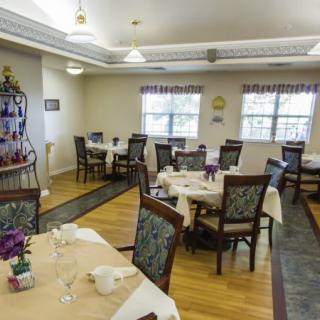 An elegantly arranged dining room with neatly set tables and chairs, ready for guests.