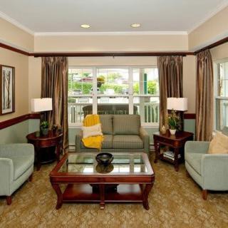 A well-furnished living room with sofas, armchairs, and a central coffee table.