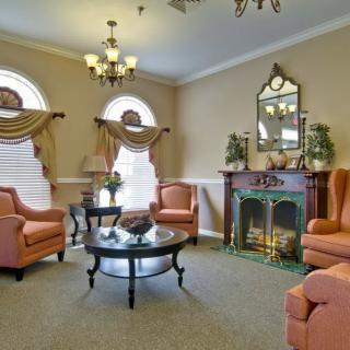 A traditional living room with comfortable armchairs and an ornate fireplace.