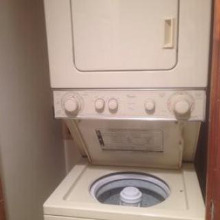 Stacked washer and dryer unit in a laundry area.