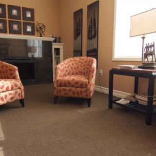A cozy living room with patterned chairs and a stylish table lamp.