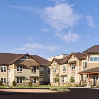 A modern residential apartment complex under a clear blue sky.