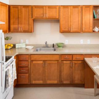 A modern kitchen with wooden cabinets, a stove, and a sink.