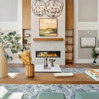 A modern living room with a central fireplace and stylish decor.