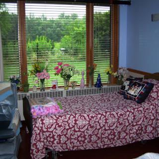 A cozy bedroom with a beautiful view of the nature outside.
