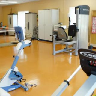 An empty gym with various exercise machines and fitness equipment.