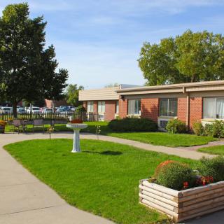 A scenic view of a building with a well-maintained garden and sidewalk.