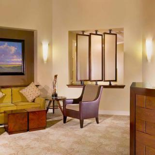 A warmly lit living room with a sofa, armchair, and decorative elements.