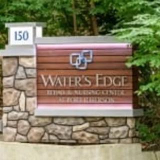 A business entrance sign for Water's Edge, nestled in a natural outdoor setting.