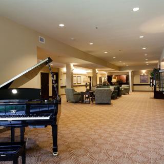 A spacious lobby interior with a grand piano and seating area.