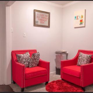 A cozy living room corner featuring two bright red chairs and modern decor.