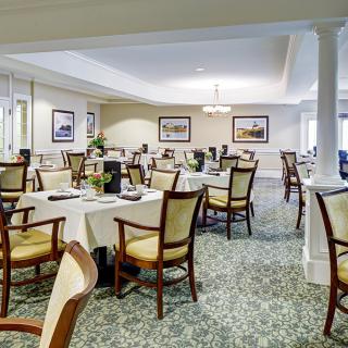 A spacious and elegantly decorated dining room with neatly arranged tables and chairs.