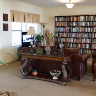 A cozy living room with a large bookshelf and comfortable seating.