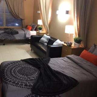 A cozy bedroom with two beds, a sofa, and stylish decor.