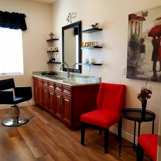 A well-decorated hair salon interior with a styling station and vibrant red chairs.