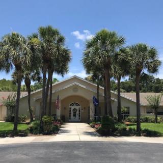 A sunny day at a building entrance framed by palm trees.