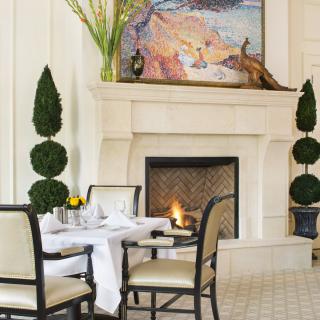 A beautifully decorated dining room with a cozy fireplace and elegant table setting.
