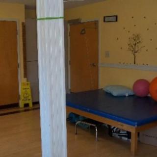 A physical therapy room with exercise balls and a treatment table.