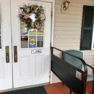 An entrance with a decorative wreath and a wheelchair ramp.