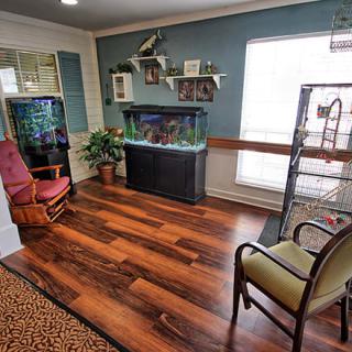 A cozy waiting area featuring an aquarium, chairs, and decorative items.