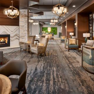 A modern, elegant lounge with a cozy fireplace and comfortable seating arrangement.