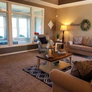 A cozy living room with a sofa, coffee table, and large windows.
