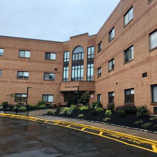 An exterior view of a modern brick building with landscaped surroundings.