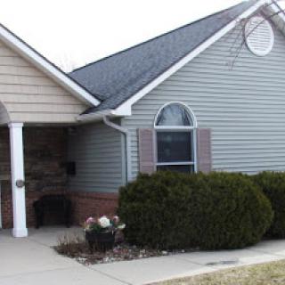 A charming single-story house with well-maintained landscaping.
