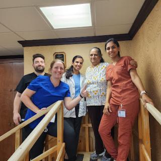 A dedicated team of healthcare professionals collaborating in a physical therapy setting.