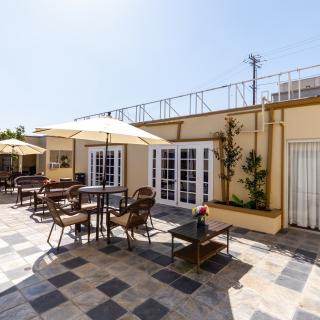 Sunny outdoor patio with tables, chairs, and umbrellas.
