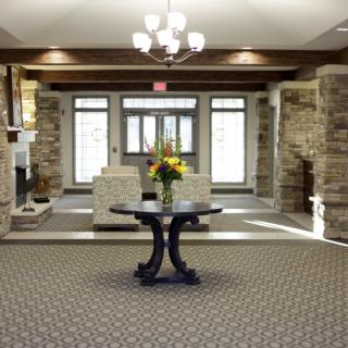 A well-decorated lobby featuring stone walls and a central table with a floral arrangement.