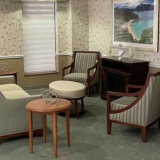 A cozy waiting room with comfortable chairs, a coffee table, and decorative artwork.