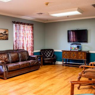 A cozy waiting room featuring comfortable seating and a television.