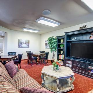 A cozy living room with a sofa, large television, and decorative elements.
