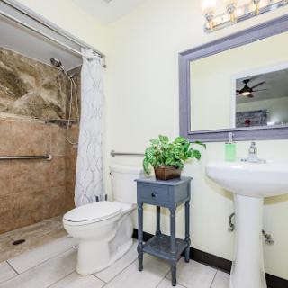 A clean and modern bathroom featuring a shower, toilet, and stylish sink.