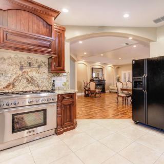 A modern kitchen with stainless steel appliances and an open layout leading to a dining area.