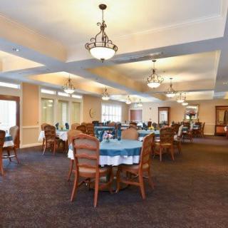 A well-lit dining area with neatly arranged tables and chairs.