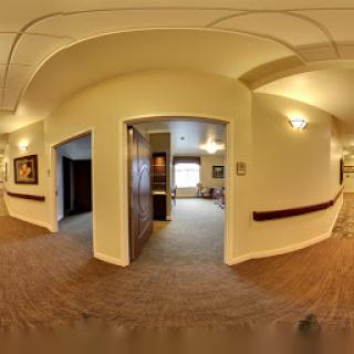 A view of a well-lit hallway featuring two entrances and decorative walls.