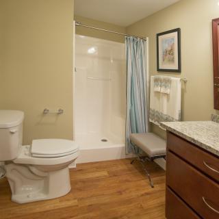 A clean and modern bathroom with a shower, toilet, and sink.