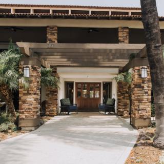 A welcoming entrance with stone pillars and outdoor seating area.