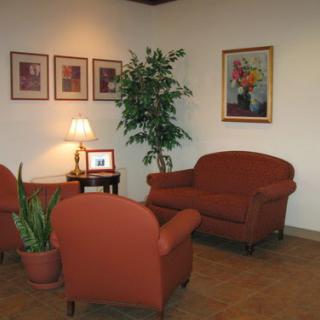A cozy living room setup featuring comfortable sofas, decorative artwork, and a touch of greenery.