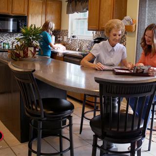 Family gathered in a kitchen, engaging in cooking and conversation.