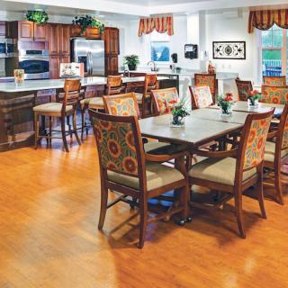 A cozy dining area with patterned chairs and a kitchen in the background.