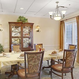 An elegant dining room featuring a large table set with chairs and a decorative chandelier.