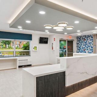 A modern reception area featuring a marble counter and contemporary lighting fixtures.