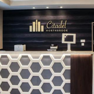 Modern reception area at Citadel hotel featuring a stylish desk and logo.